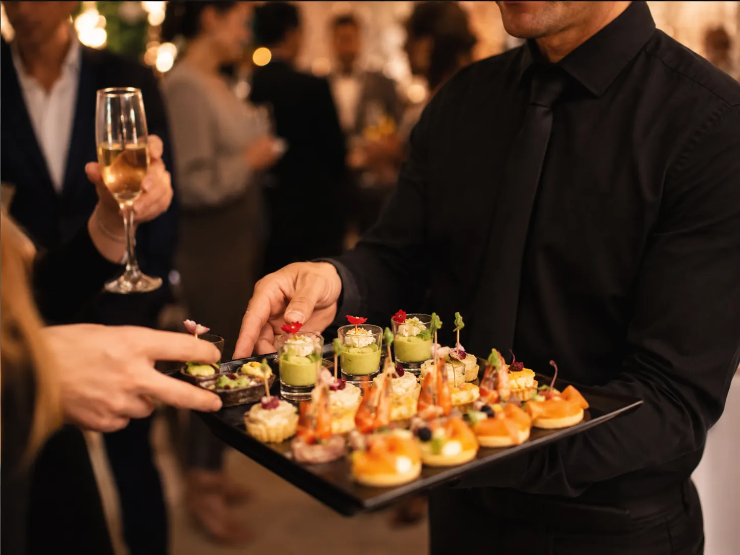 Plateau de pièces cocktail et coupes de champagne servi par notre maître d'hôtel lors d'un cocktail d'entreprise à Bron — réalisation Maison Désir & Gourmandise